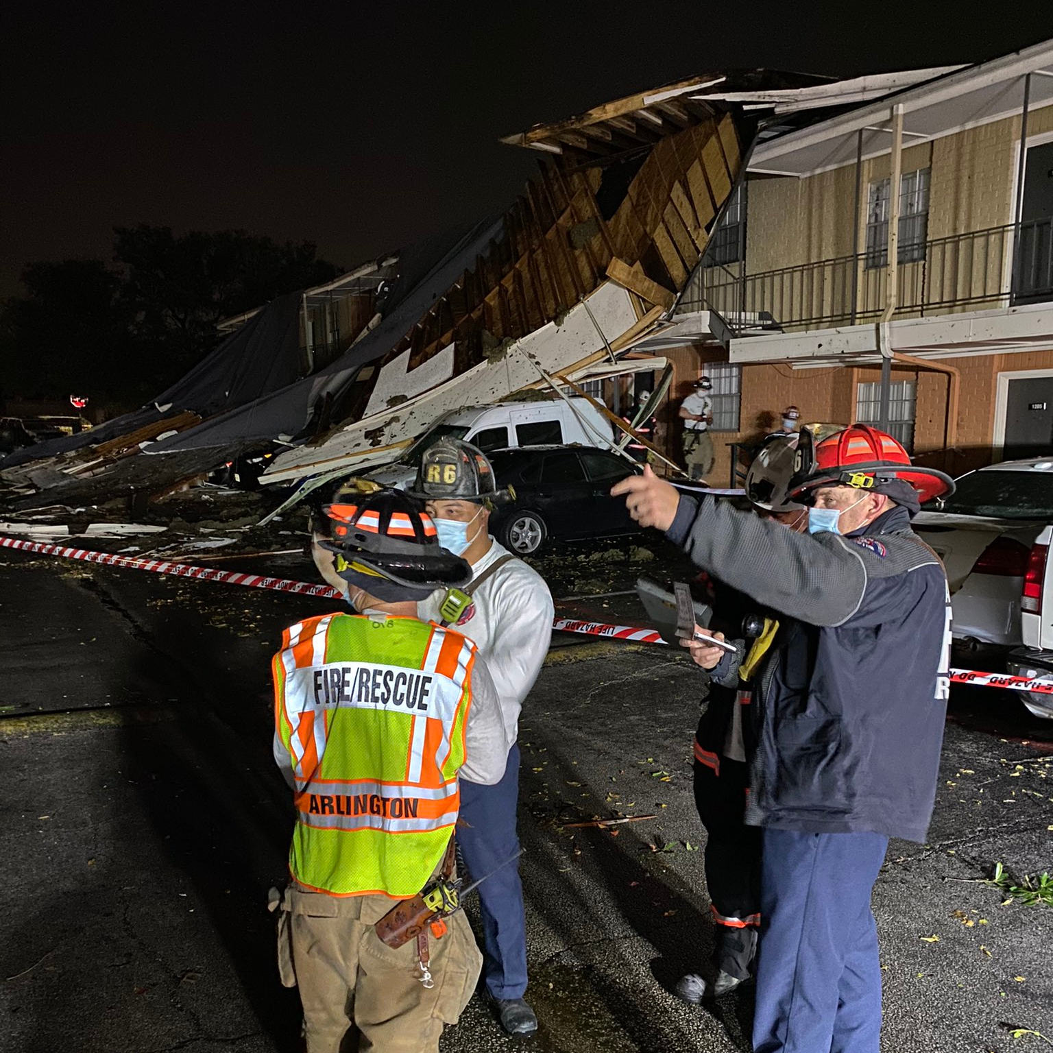 Arlington, TX, firefighters survey the damage done by a tornado and severe thunderstorms late Tuesday.