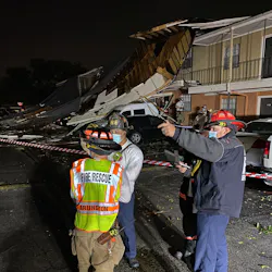 Arlington, TX, firefighters survey the damage done by a tornado and severe thunderstorms late Tuesday.