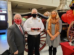 Fire Chief Michael Stanley (center) was presented with the Firefighter Hero Award by Oshkosh City Manager Mark Rohloff, and Jennifer Skolaski, who consulted with Chief Stanley on a falls prevention initiative and who nominated him for the award. Fire Chief Michael Stanley (center) was presented with the Firefighter Hero Award by Oshkosh City Manager Mark Rohloff, and Jennifer Skolaski, who consulted with Chief Stanley on a falls prevention initiative and who nominated him for the award.