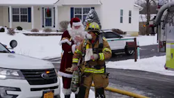 Cicero, NY, Fire Chief George Barrett gets a hand from a firefighter dressed as Santa Claus at the scene of a residential fire Saturday. Cicero, NY, Fire Chief George Barrett gets a hand from a firefighter dressed as Santa Claus at the scene of a residential fire Saturday.