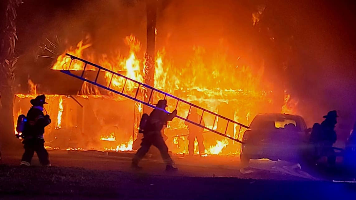 Crews from multiple departments battled a raging residential fire in Belleview, FL, on Friday, and firefighters saved a woman and two dogs from the flames.