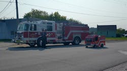 For comparison, an full-size apparatus is parked next to Mike Kalman custom-built mini-fire apparatus.