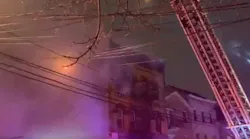 A firefighter was injured by falling debris while battling a four-alarm fire at a Passaic County, NJ, apartment building early Thursday.