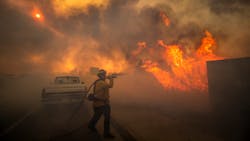 Firefighter Raymond Vasquez braves tall flames as he fights the advancing Silverado Fire, fueled by Santa Ana winds, at the 241 toll road and Portola Parkway in Irvine, CA, on Oct. 26. Firefighter Raymond Vasquez braves tall flames as he fights the advancing Silverado Fire, fueled by Santa Ana winds, at the 241 toll road and Portola Parkway in Irvine, CA, on Oct. 26.