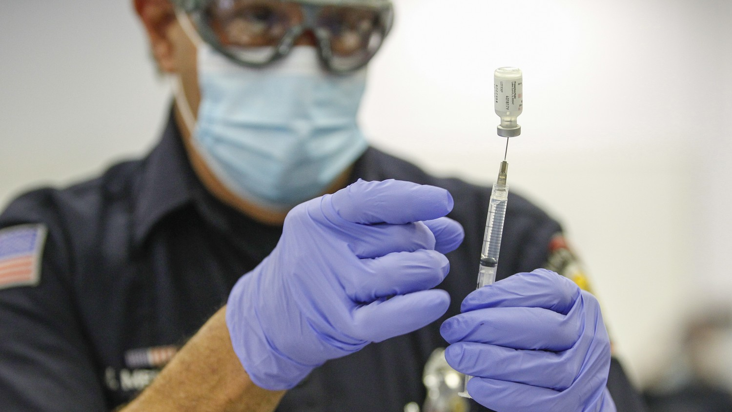Firefighter-paramedic Mitch Mendler prepares a Pfizer COVID-19 vaccine for a recipient at the San Diego Fire-Rescue Training Facility on Dec. 31.