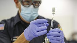 Firefighter-paramedic Mitch Mendler prepares a Pfizer COVID-19 vaccine for a recipient at the San Diego Fire-Rescue Training Facility on Dec. 31. Firefighter-paramedic Mitch Mendler prepares a Pfizer COVID-19 vaccine for a recipient at the San Diego Fire-Rescue Training Facility on Dec. 31.