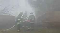 Firefighters work to put out a fire from a small plane that crashed and exploded in the backyard of a Columbia, SC, home Wednesday.