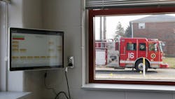 A fire apparatus drives by the Columbus, OH, Division of Fire&apos;s new Station 16, which opened Wednesday. The computer monitor seen in the foreground can dispatch firefighters individually by assignment in their dorm rooms without having to wake an entire company if not everyone is needed.