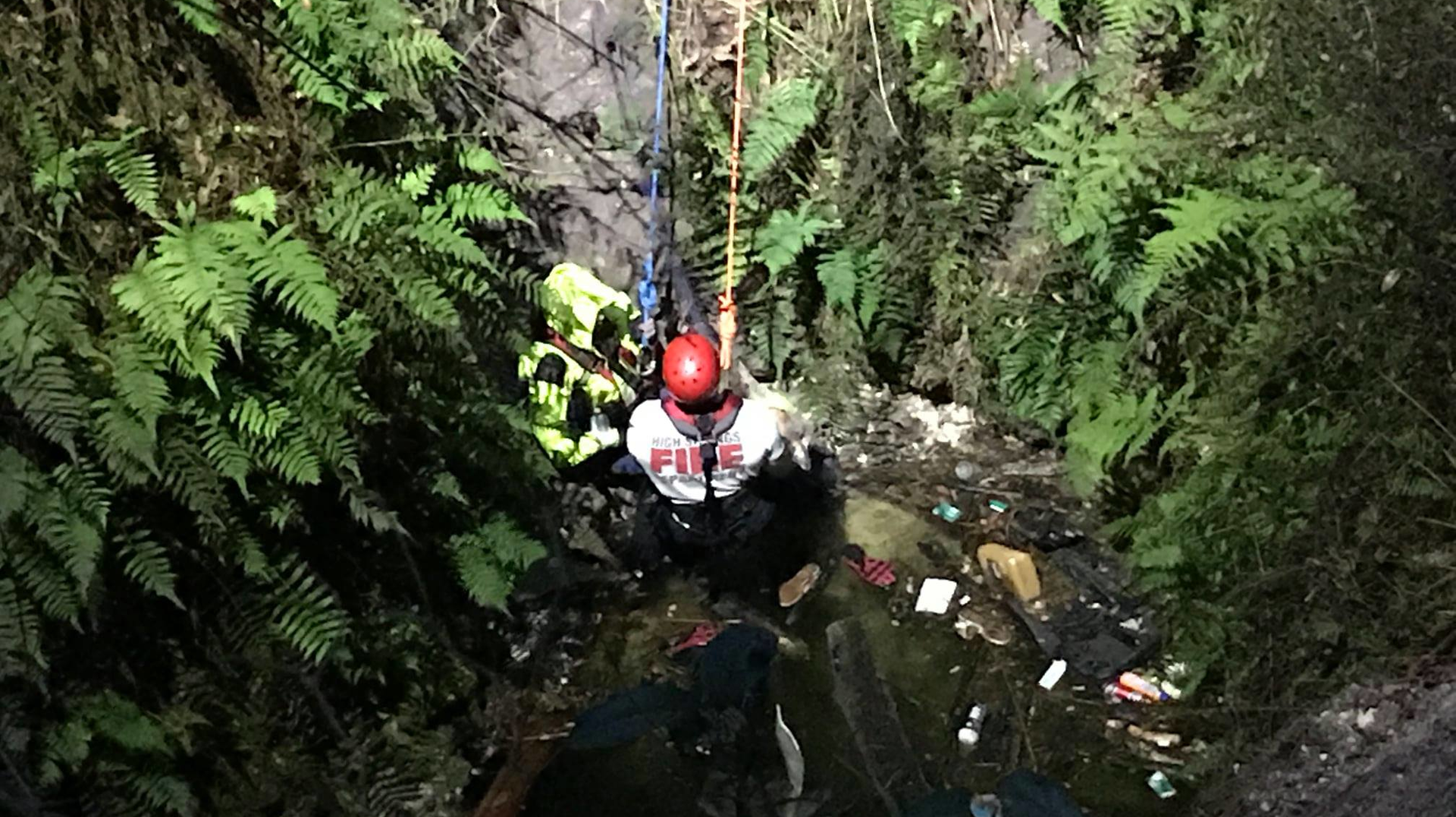 A High Springs, FL, firefighter rappels down a 40-foot deep sinkhole to rescue a woman who had been trapped in the water-filled chasm for nearly 11 hours Thursday.