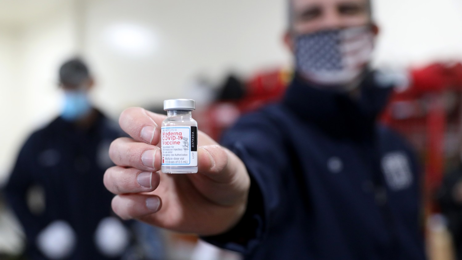 Los Angeles Mayor Eric Garcetti holds a vile of the Moderna COVID-19 vaccination while LAFD firefighters receive the vaccine at Station 4 on Dec. 28.