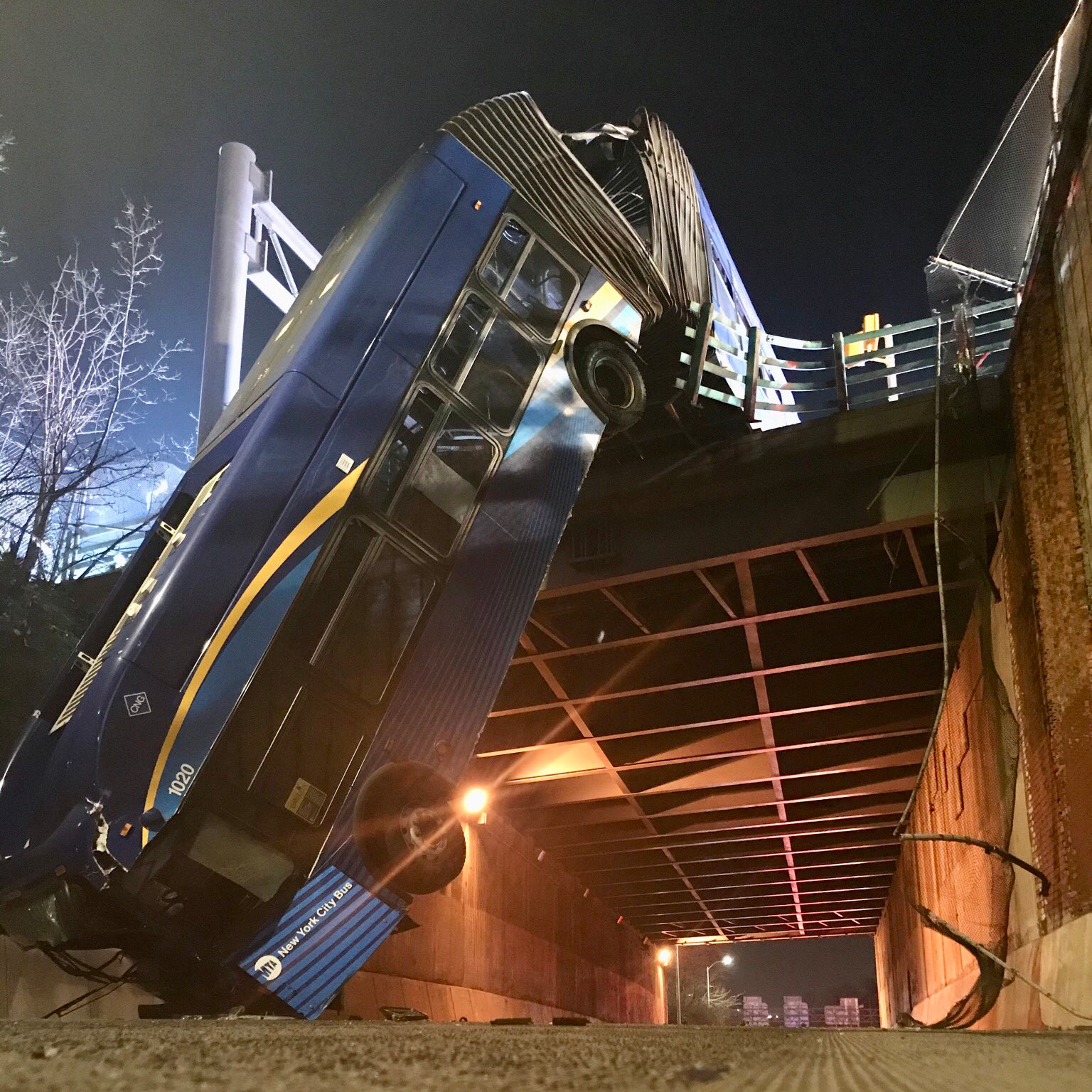 At least eight people were injured when a New York City tandem bus crashed through traffic barriers in the Bronx and fell 50 feet to the road below Thursday, leaving the vehicle dangling off an overpass.