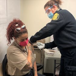 A member of the Philadelphia Fire Department is vaccinated for COVID-19. The department has begun vaccinating personnel, and by Tuesday, 100 members had received the shot.