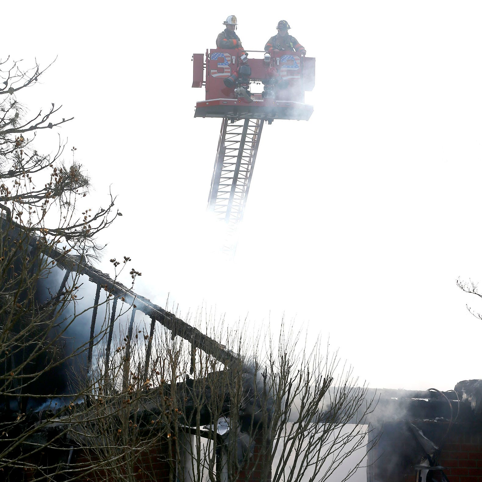 Smoke envelopes firefighters above a Manchester, NJ, duplex that was gutted by flames Friday.