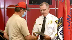 Canton, OH, Fire Chief Thomas Garra presents a Good Samaritan award to Norman Yoder, who used his ladder to help four people flee a burning house.