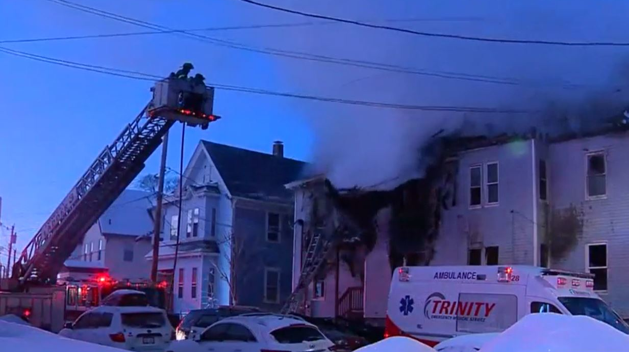 A section of a home's roof collapses during a 3-alarm fire in Lowell, MA, on Wednesday, Feb. 10, 2021.