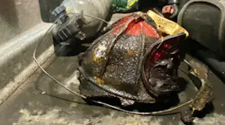 A battered Boston firefighter's helmet was recovered from the wreckage of a burned out apartment in the Roxbury neighborhood after a roof collapse during a three-alarm fire Monday.