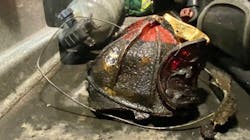 A battered Boston firefighter&apos;s helmet was recovered from the wreckage of a burned out apartment in the Roxbury neighborhood after a roof collapse during a three-alarm fire Monday.