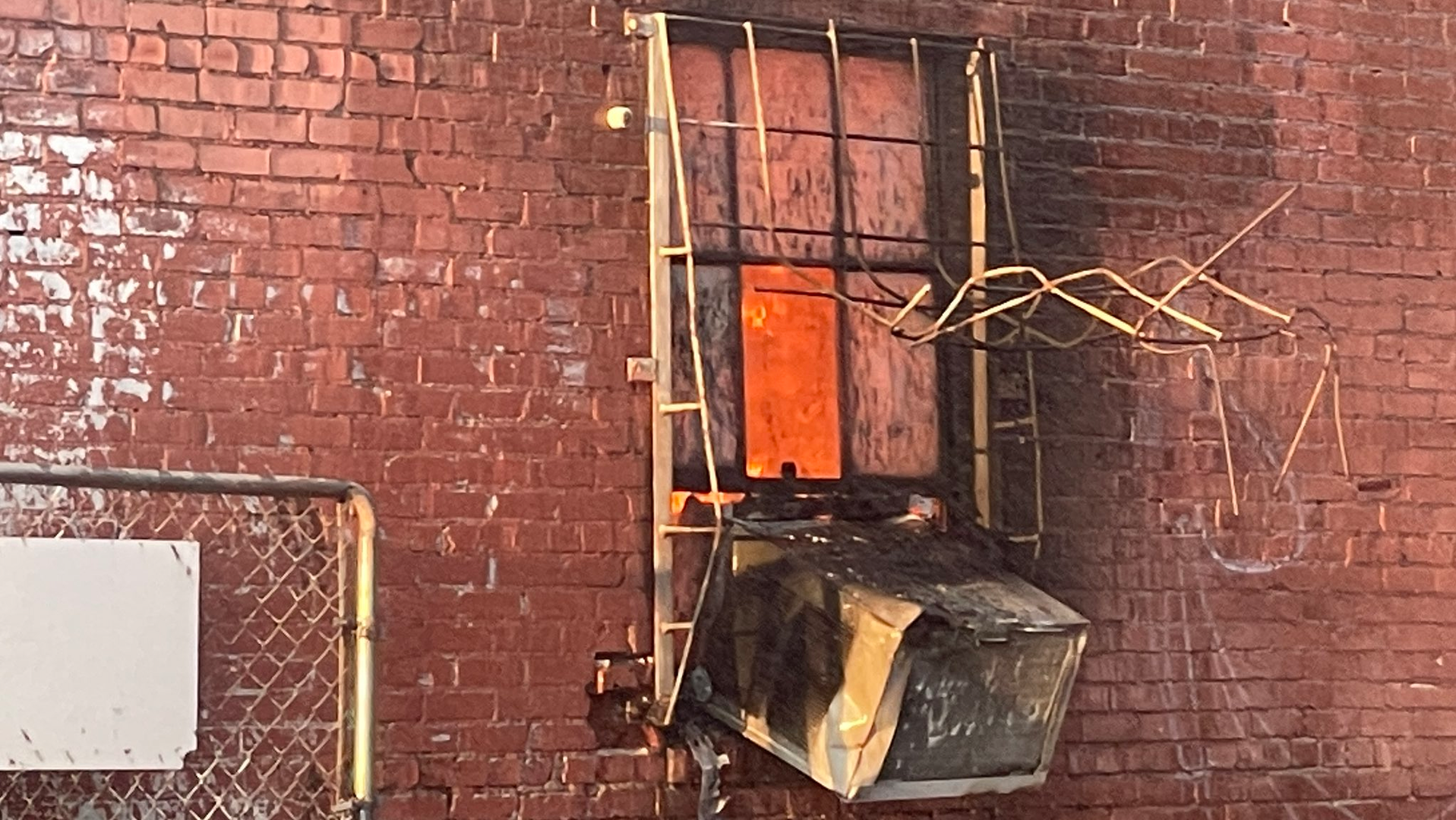 Oklahoma City, OK, firefighters needed to remove metal window bars to rescue a woman from a four-alarm fire moments before flames engulfed a commercial building Tuesday.