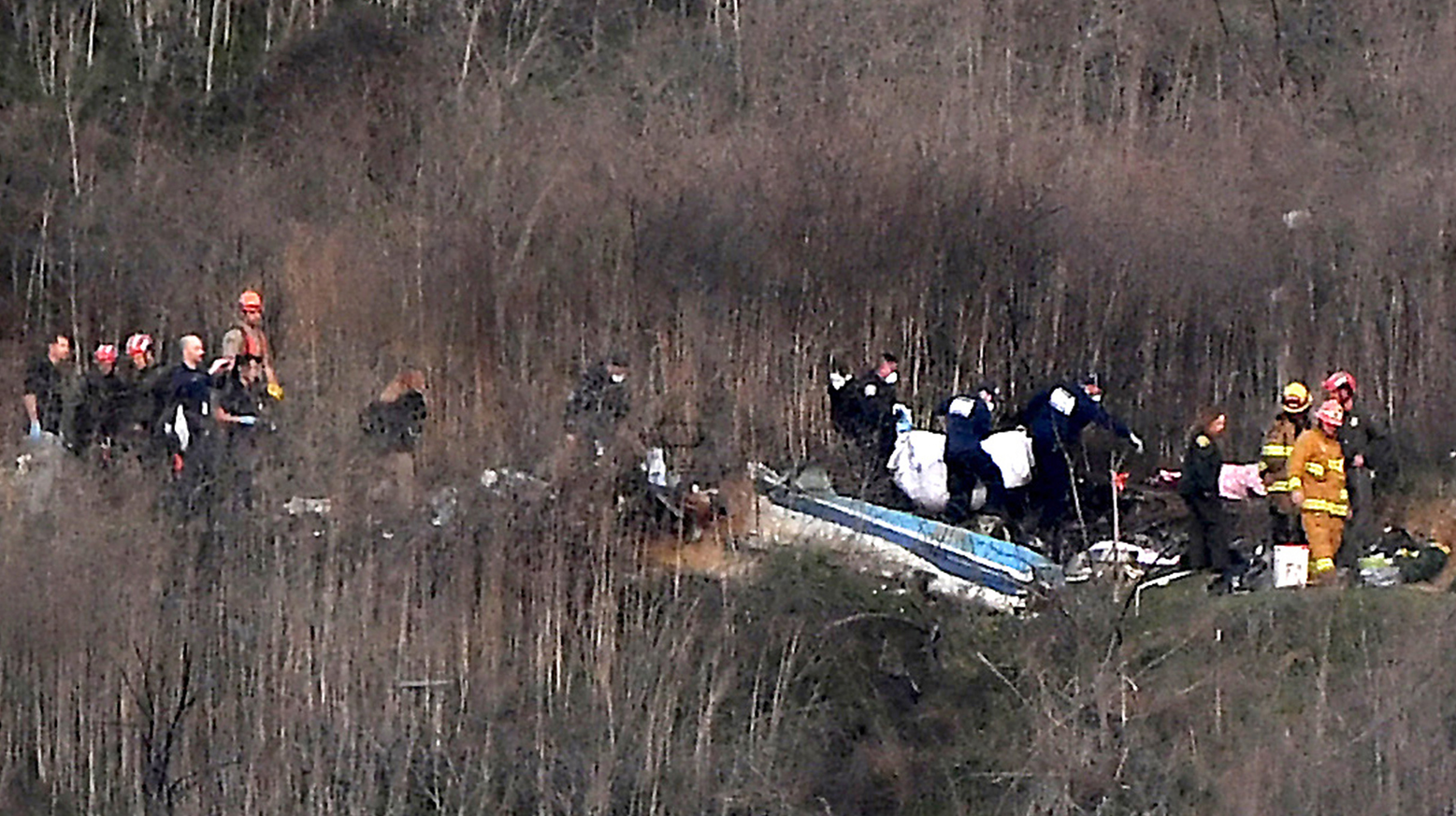 Officials remove a body from the wreckage of a helicopter crash that killed nine people, including NBA star Kobe Bryant, in Calabasas, CA, on Jan. 26, 2020.