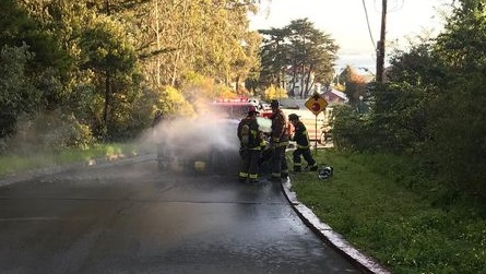 San Francisco firefighters saved an unconscious man trapped in a burning car following a solo-vehicle collision Sunday.