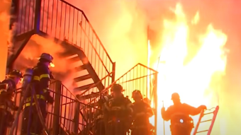 Firefighters battle a massive fire that erupted at a Spring Valley, NY, assisted living facility Tuesday, killing a resident and a firefighter.