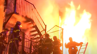 Firefighters battle a massive fire that erupted at a Spring Valley, NY, assisted living facility Tuesday, killing a resident and a firefighter.