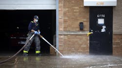 A Chicago firefighter cleans up blood as Chicago police officers work the scene of a mass shooting Sunday morning. A Chicago firefighter cleans up blood as Chicago police officers work the scene of a mass shooting Sunday morning.