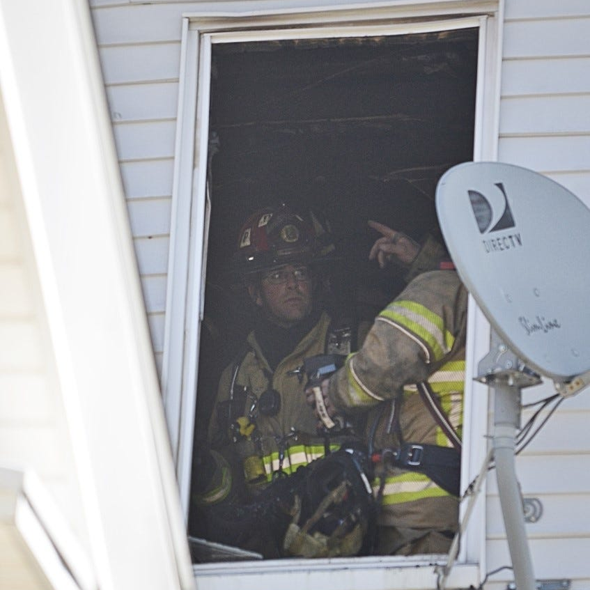 Firefighters work in an apartment at 133-135 Main St. after a fire broke out there Tuesday.