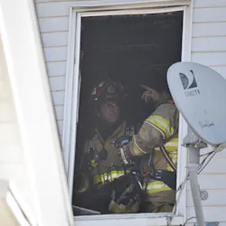 Firefighters work in an apartment at 133-135 Main St. after a fire broke out there Tuesday.