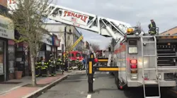 Around 125 firefighters from multiple departments worked for nearly 90 minutes to put out a five-alarm blaze that erupted at a row of stores in a century-old building in Bergenfield, NJ, on Saturday.