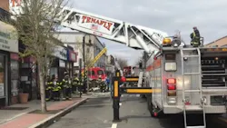 Around 125 firefighters from multiple departments worked for nearly 90 minutes to put out a five-alarm blaze that erupted at a row of stores in a century-old building in Bergenfield, NJ, on Saturday.