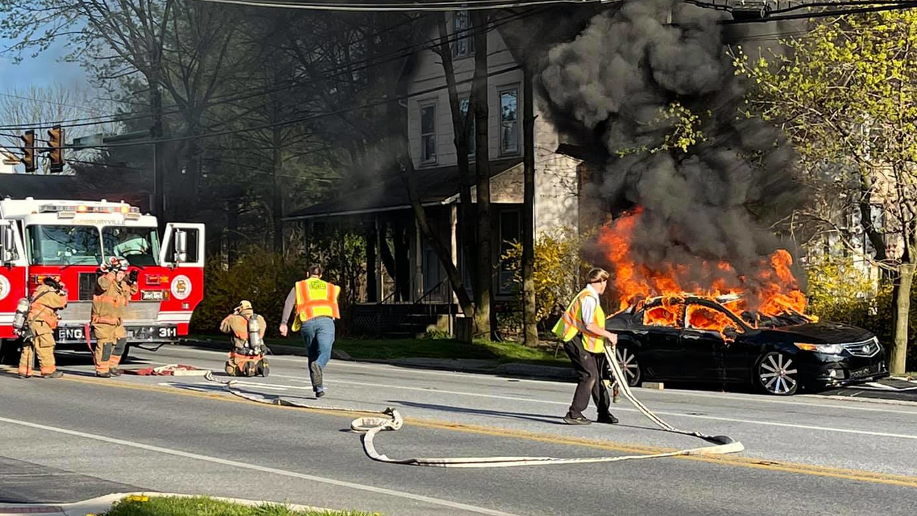 Sadsbury, PA, firefighters extinguish a burning car that rolled down a hill Tuesday.