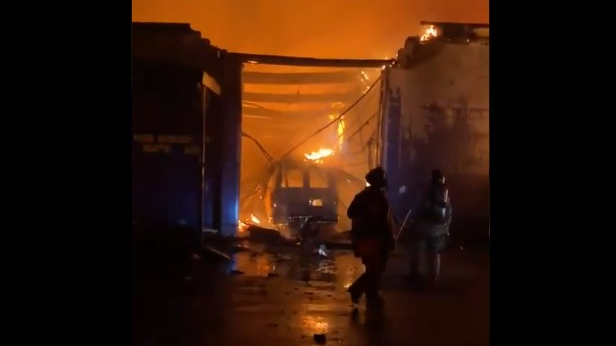 Atlanta firefighters battled a massive warehouse fire late Thursday that threatened an aerial and forced crews to evacuate it.