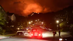 Flames from the Palisades Fire glow in the distance in Topanga, CA, northwest of Los Angeles, on May 15.