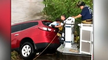 Portales, NM, firefighters rescue a mother and her children after their SUV was swept away by fast-moving floodwaters Saturday.