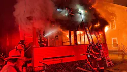 Webster, MA, firefighters used a neighbor's ladder to rescue a woman clinging to the roof of a burning three-family home late Wednesday.