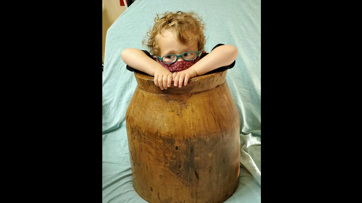 Dorian Strubing, 2, is pictured at an emergency room stuck inside an antique wooden barrel before Portland, TN, firefighters arrived and carefully extricated him.