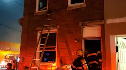 Philadelphia firefighters rescued two children hanging from a second-story window of a burning rowhouse in the city's Bridesburg neighborhood early Wednesday.