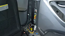 This Hyundai Elantra has spool-rewinding seatbelt pretensioners. With the trim removed, the unit is visible. The yellow wiring provides power to the pretensioner. The side-impact crash sensor is the yellow block that’s higher up on the B-pillar.