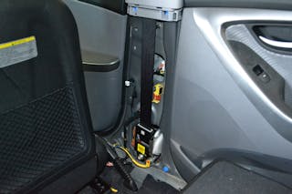This Hyundai Elantra has spool-rewinding seatbelt pretensioners. With the trim removed, the unit is visible. The yellow wiring provides power to the pretensioner. The side-impact crash sensor is the yellow block that&rsquo;s higher up on the B-pillar.