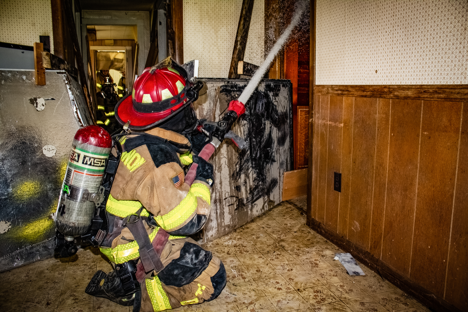 A firefighter of a rural department trains on moving hoselines with only two firefighters.