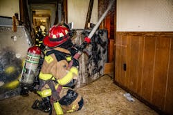 A firefighter of a rural department trains on moving hoselines with only two firefighters. A firefighter of a rural department trains on moving hoselines with only two firefighters.