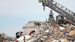 Firefighters work alongside K-9 units while searching the rubble of the Champlain Towers South Condo.