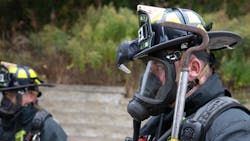 A firefighter helps test a new C-Thru Navigator helmet mount that gives firefighters a better view of a fire scene.
