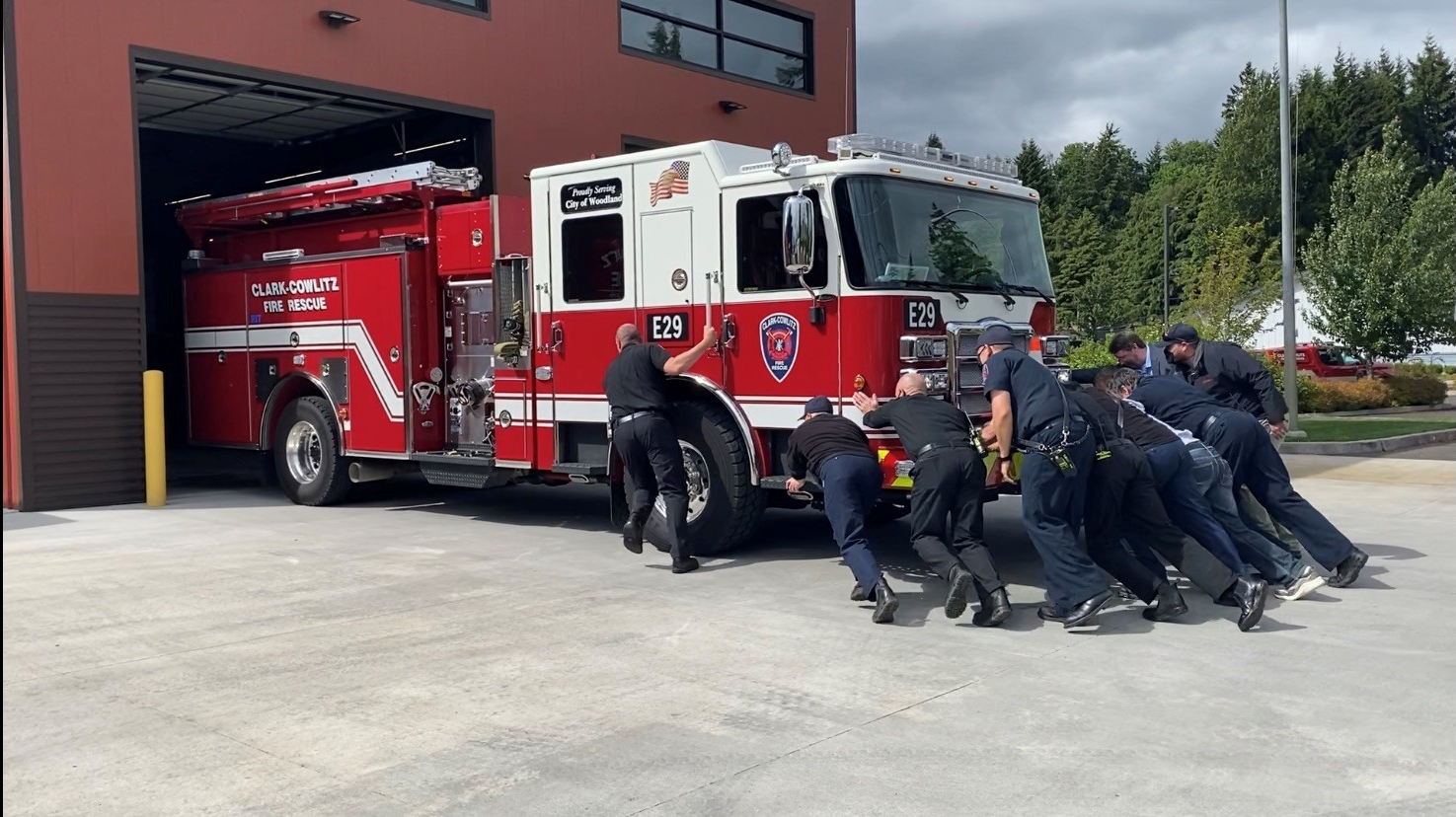 Clark-Cowlitz Fire Rescue firefighters push in a newly purchased apparatus to its Woodland, WA, station May 25, the first time the firehouse has received a new engine in 21 years.