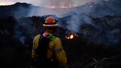 A firefighter watches the flames from the Palisades fire glow in the distance in Topanga State Park, North West of Los Angeles on May 15, 2021. - A brush fire near Pacific Palisades started Friday and grew to 750 acres Saturday nt, triggering a mandatory evacuation of residents in the Topanga area. ( A firefighter watches the flames from the Palisades fire glow in the distance in Topanga State Park, North West of Los Angeles on May 15, 2021. - A brush fire near Pacific Palisades started Friday and grew to 750 acres Saturday nt, triggering a mandatory evacuation of residents in the Topanga area. (