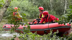 Biloxi, MS, and Harrison County firefighters rescue a kayaker who was hanging on to a tree after flipping over in a fast-moving, flooded creek Sunday.