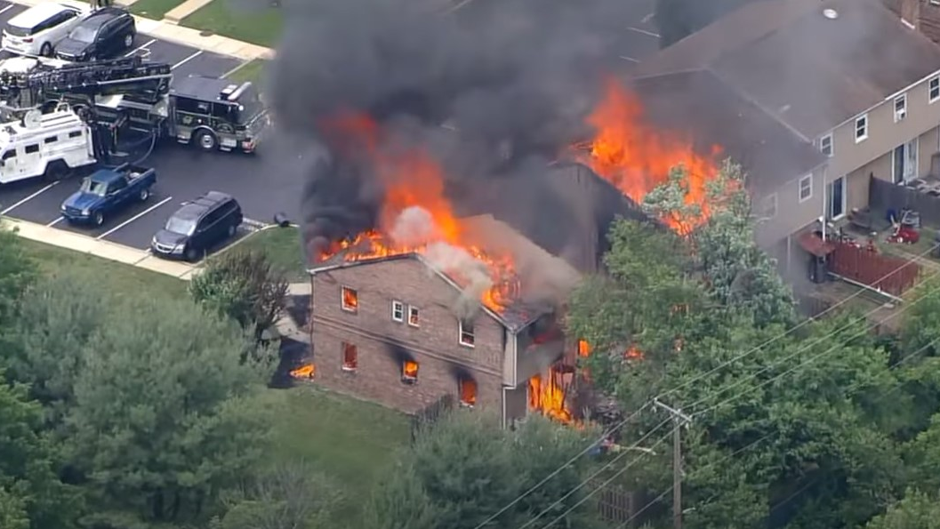 A Lower Providence Township, PA, code enforcement officer was threatened by a man with a gun moments before multiple explosions and a large fire tore through apartments Thursday.