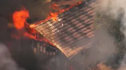 A two-alarm fire collapsed two Pleasant Hills, CA, homes and burned a Contra Costa County firefighter Monday.