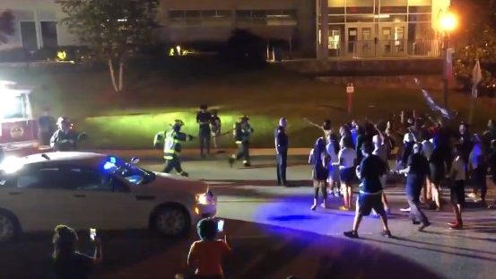 A Rock Hill, SC, police officer helps clear the way for firefighters to reach a fire started outside police headquarters Wednesday.